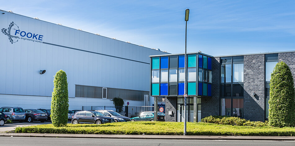 Das Servicegebäude der FOOKE GmbH in Borken mit türkis, blauen und grauen Elementen im Sonnenschein.