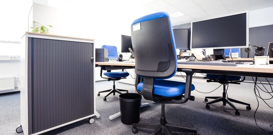 Blick auf drei Büroarbeitsplätze mit Stühle und Schreibtische